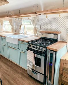 a kitchen with blue cabinets and an oven in it's center, next to a sink