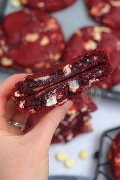 a hand holding a half eaten red velvet cookie