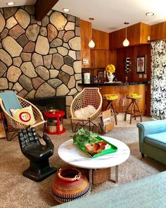 a living room filled with furniture next to a stone wall