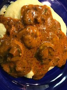 a blue plate topped with meatballs and mashed potatoes