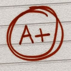 a red circle with the letter a and cross drawn in it on top of a white wall