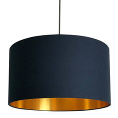 a black and gold lamp shade hanging from a ceiling fixture with a chain attached to it