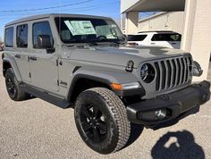 a gray jeep parked in a parking lot