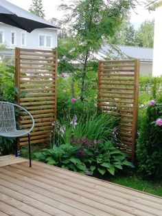 a wooden deck surrounded by plants and flowers