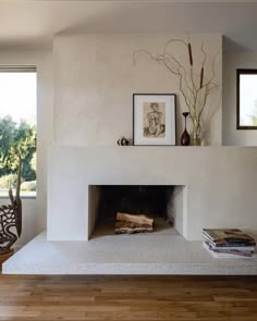 a living room filled with furniture and a fire place in the middle of a wooden floor