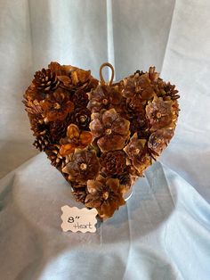 a heart shaped decoration made out of pine cones