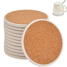 a stack of cork coasters next to a white coffee cup and saucer on a white background