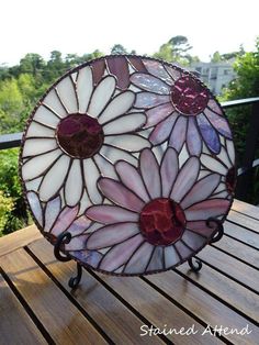 a stained glass sun catcher sitting on top of a wooden table