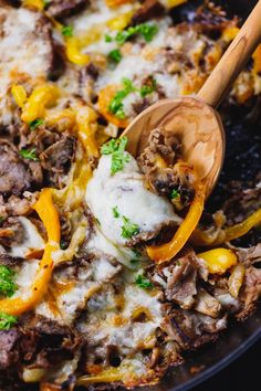 a skillet filled with meat, cheese and peppers