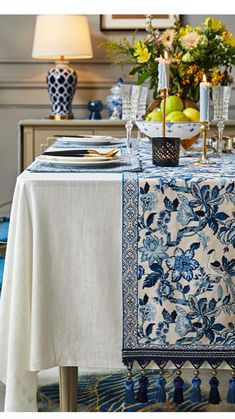 a blue and white table cloth with tassels on it in a dining room