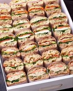 a white box filled with lots of sandwiches