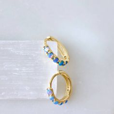 Revision Blue Opal Huggie Hoop Earrings will help you manifest your wildest dreams! These earrings features blue opals, creating a bold look that will help you take risks and live an adventurous life. Reach for your goals with these daring earrings! One touch gold plated over sterling silver huggie Ideal for sensitive ears Details: • MATERIAL: 18K gold plated over sterling silver, lab opal stones • HOOP SIZE: 8mm Adventurous Life, Silver Lab, Wildest Dreams, Blue Gems, Take Risks, Huggie Hoop Earrings, Sensitive Ears, Blue Opal, Gold Hoop