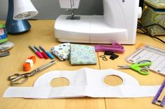 sewing supplies are laid out on a table next to a sewing machine and other crafting supplies