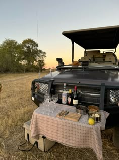 a man standing next to a table with food and drinks in front of an suv