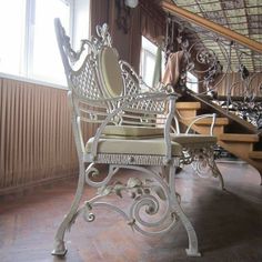 a chair sitting on top of a hard wood floor next to a stair case in a building