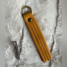 a leather keychain sitting on top of a white blanket