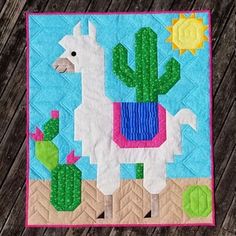 a quilted wall hanging with a llama and cactus