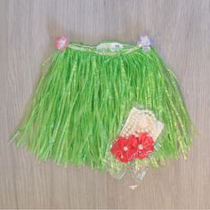 a green skirt with flowers on the bottom and a flower in the middle, sitting on top of a table