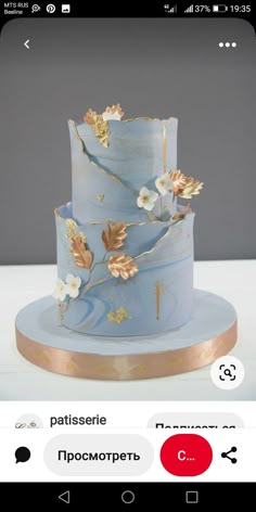 a blue and gold wedding cake with flowers on it