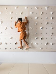 a young boy climbing up the side of a rock wall