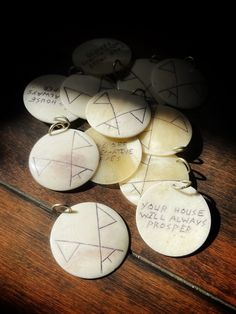 several white buttons with writing on them sitting on a wooden table next to each other