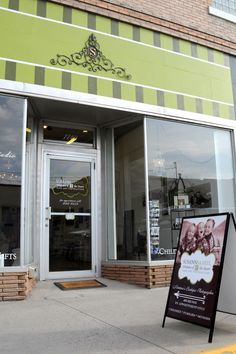 the front of a store with an advertisement on it's door and sign in front