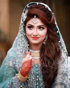 a woman wearing a bridal outfit and jewelry