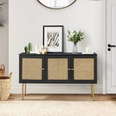 a black and gold sideboard with wicker baskets on it in front of a mirror