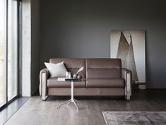 a living room with a couch, coffee table and large windows