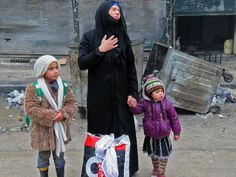 a man, woman and child walking down the street