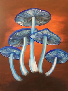 three blue mushrooms sitting on top of a brown surface