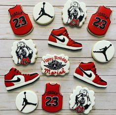 decorated cookies are arranged in the shape of shoes and basketball jerseys, on a wooden surface