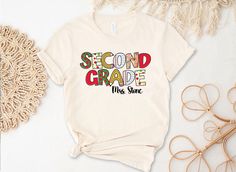 a t - shirt with the words second grade on it next to some other items