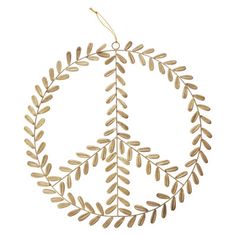 a peace sign hanging from the side of a wooden tree branch with leaves on it