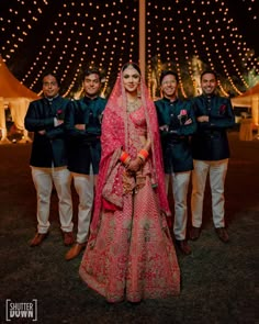 a bride and groom posing for a photo with their bridal party in the background