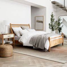 a bedroom with a bed, dresser and mirror on the wall next to a stair case