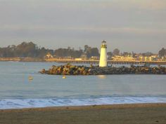 a light house sitting on top of a beach next to the ocean