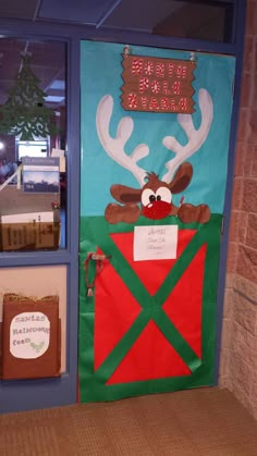 a door decorated with reindeer's in a red and green barn