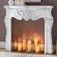 candles are lit in front of an ornate white fireplace mantel with carved carvings and scrolls