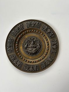 a decorative metal plate with a lion on it's center and two smaller lions in the middle