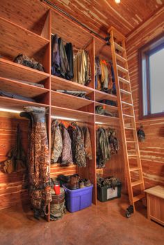 a room with wooden walls and shelves filled with clothes