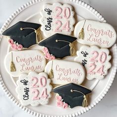 decorated cookies with graduation caps and tassels are on a white plate that says congrats lauren