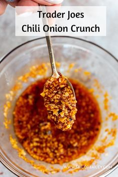 a spoon full of chili onion crunch in a glass bowl with the words trader joe's chili onion crunch on it