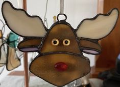 a stained glass moose ornament hanging from a hook in a room with other ornaments