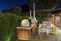 an outdoor kitchen and dining area is lit up at night