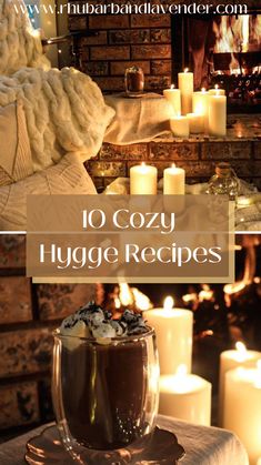 two mugs filled with hot chocolate sitting on top of a table next to candles