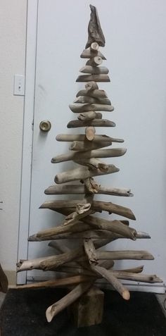 a wooden christmas tree made out of driftwood