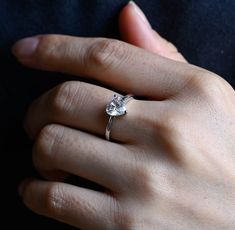 a woman's hand with a diamond ring on it