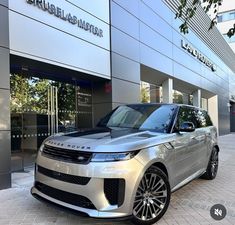 a silver range rover parked in front of a building