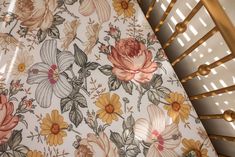 a close up view of a flowered crib sheet with gold trimmings